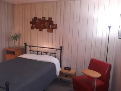 a bedroom with a bed and a red chair at Clubhouse Lakeview Chalet in East Stroudsburg