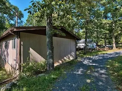 a building with a tree next to a road at Clubhouse Lakeview Chalet in East Stroudsburg