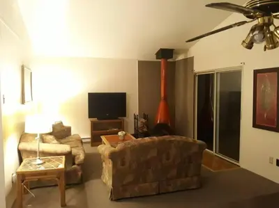 a living room with a couch and a flat screen tv at Clubhouse Lakeview Chalet in East Stroudsburg