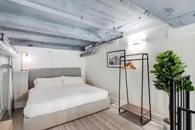 a bedroom with a white bed and a plant at The Ledger Residences by Sosuite - Old City in Philadelphia