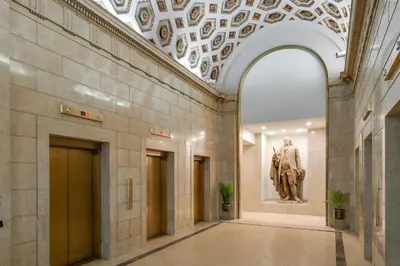 a hallway in a museum with a statue on the wall at The Ledger Residences by Sosuite - Old City in Philadelphia