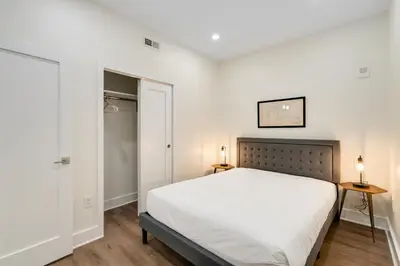 a white bedroom with a bed and a closet at The Ledger Residences by Sosuite - Old City in Philadelphia