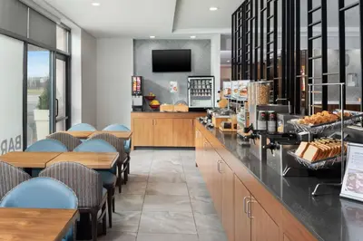 a restaurant with wooden tables and chairs and a counter at Fairfield Inn & Suites by Marriott New York Staten Island in Staten Island