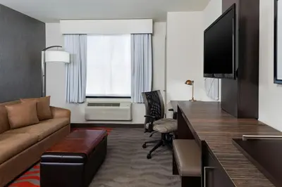 a living room with a couch and a flat screen tv at Fairfield Inn & Suites by Marriott New York Staten Island in Staten Island