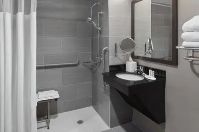a bathroom with a sink and a shower with a mirror at Fairfield Inn & Suites by Marriott New York Staten Island in Staten Island