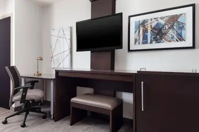 a hotel room with a desk with a tv and a chair at Fairfield Inn & Suites by Marriott New York Staten Island in Staten Island