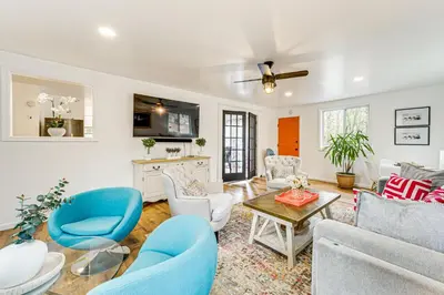 a living room with blue chairs and a table at Deck, Fire Pit and Pool Access at Poconos Retreat! in East Stroudsburg