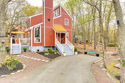 a red barn house with a driveway at Deck, Fire Pit and Pool Access at Poconos Retreat! in East Stroudsburg