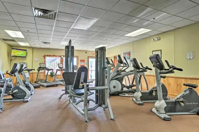 a gym with a lot of treadmills and exercise bikes at Deck, Fire Pit and Pool Access at Poconos Retreat! in East Stroudsburg