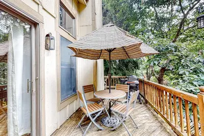 a table and two chairs and an umbrella on a porch at Northridge 393 in Tannersville