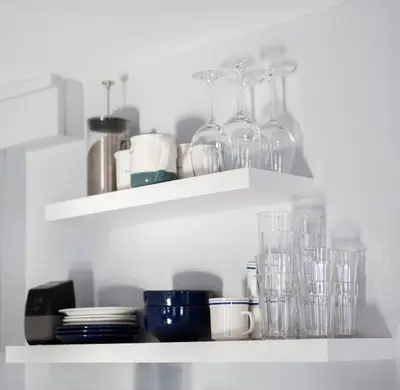 a shelf with glasses and plates and cups on it at Lakeside Reflections in Oxford