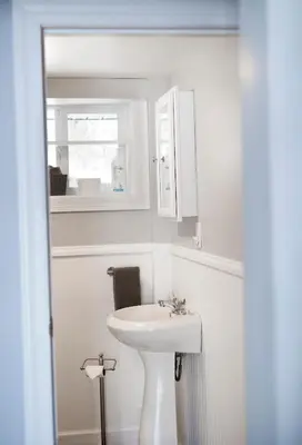 a white bathroom with a sink and a window at Lakeside Reflections in Oxford