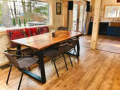 a wooden table and chairs in a room at Charming 120-year-old farmhouse by the creek. in Starlight