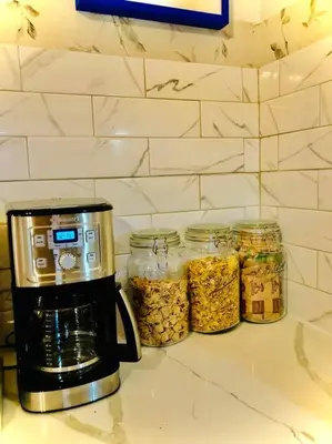 a coffee maker and jars of food on a counter at Charming 120-year-old farmhouse by the creek. in Starlight