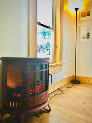 a fireplace in a living room with a window at Charming 120-year-old farmhouse by the creek. in Starlight