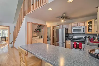 a kitchen with a granite counter top and wooden cabinets at Deck, Pool, Trails Access Pocono Family Home! in Albrightsville