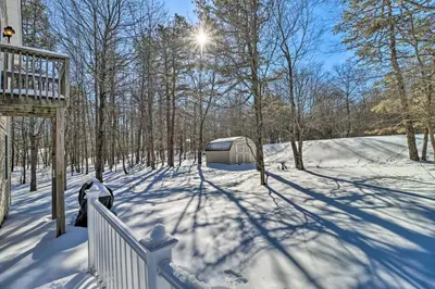 a snow covered yard with a fence and trees at Deck, Pool, Trails Access Pocono Family Home! in Albrightsville