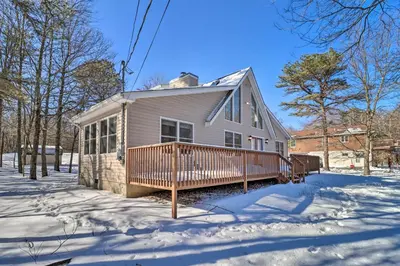 a house with a deck in the snow at Deck, Pool, Trails Access Pocono Family Home! in Albrightsville