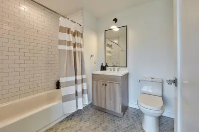 a bathroom with a toilet and a sink and a tub at Harmony Lofts on Jackson 2 in Hoboken