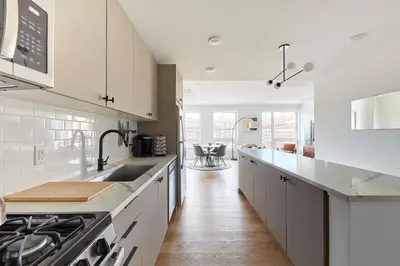 a white kitchen with a sink and a stove at Harmony Lofts on Jackson 2 in Hoboken