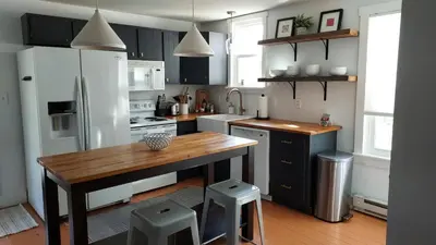 a kitchen with a wooden table and a white refrigerator at Lewisburg duplex in Lewisburg
