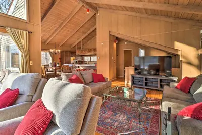 a living room with couches and a flat screen tv at Fire Pit and Grill Lakefront Poconos Cottage! in East Stroudsburg