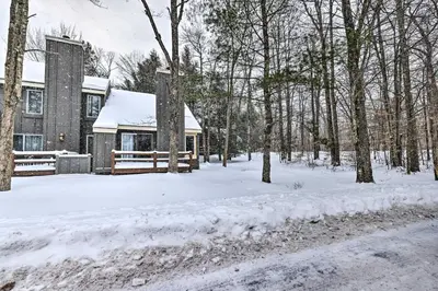 a house covered in snow in the woods at Less Than 1 Mi to Jack Frost Lake Harmony Townhome! in Lake Harmony