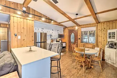 a kitchen with wooden walls and a table and chairs at Near Skiing Pocono Lake Cabin with Screened Patio in Pocono Lake