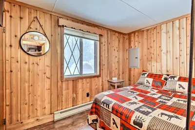 a bedroom with wooden walls and a bed in a room at Near Skiing Pocono Lake Cabin with Screened Patio in Pocono Lake