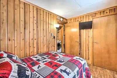 a bedroom with wooden walls and a bed with a quilt at Near Skiing Pocono Lake Cabin with Screened Patio in Pocono Lake