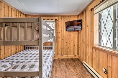 a bedroom with a bunk bed and a tv at Near Skiing Pocono Lake Cabin with Screened Patio in Pocono Lake