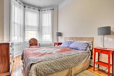 a bedroom with a bed and two tables and two windows at Contemporary Jersey City Abode about 5 Mi to NYC! in Jersey City