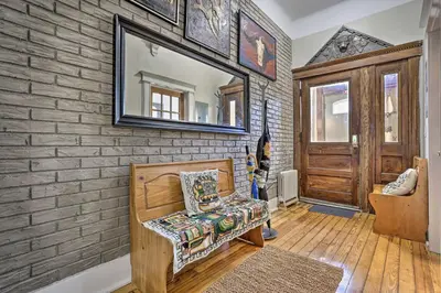 a room with a brick wall with a chair and a mirror at Contemporary Jersey City Abode about 5 Mi to NYC! in Jersey City