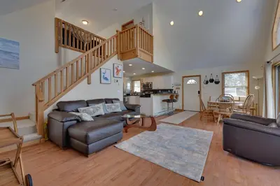 a living room with a couch and a staircase at Large Deck and Resort Amenities Lake Ariel Retreat in Lake Ariel