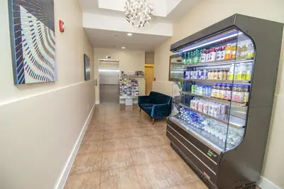a pharmacy aisle with a refrigerator filled with drinks at Canal Loft Hotel in New York