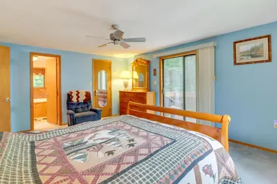 a bedroom with a bed and a chair at Lake Access and Decks Pet-Friendly Poconos Cabin! in Pocono Lake