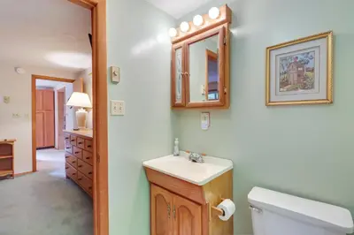 a bathroom with a sink and a toilet and a mirror at Lake Access and Decks Pet-Friendly Poconos Cabin! in Pocono Lake