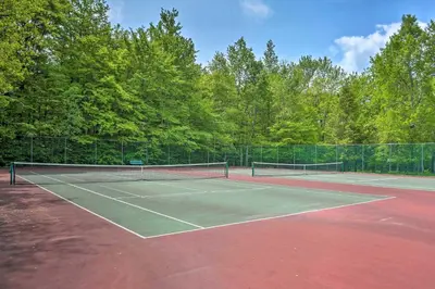 a tennis court with two tennis rackets on it at Lake Access and Decks Pet-Friendly Poconos Cabin! in Pocono Lake