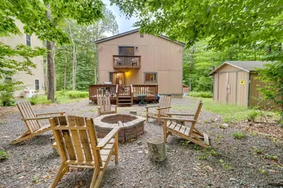 a backyard with chairs and a fire pit and a barn at Lake Access and Decks Pet-Friendly Poconos Cabin! in Pocono Lake