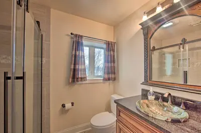 a bathroom with a sink and a toilet and a mirror at Dock and Hot Tub Susquehanna River Retreat! in Pequea
