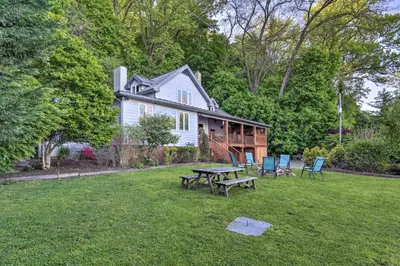 a house with a picnic table and chairs in the yard at Dock and Hot Tub Susquehanna River Retreat! in Pequea