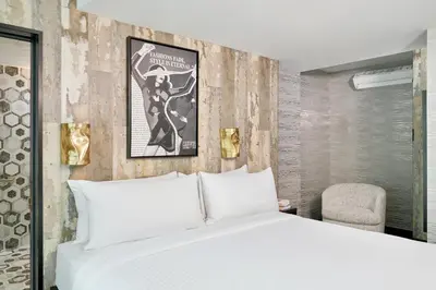 a bedroom with a white bed and a chair at The FIDI Hotel in New York