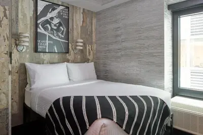a bed in a room with a person sitting on it at The FIDI Hotel in New York