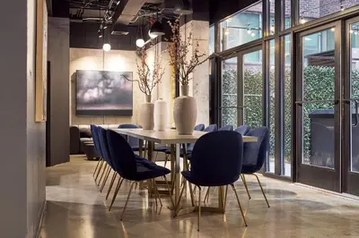 a dining room with a table and blue chairs at The FIDI Hotel in New York