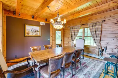 a dining room with a wooden table and chairs at Luxury Log Cabin with EV Charger and Mtn Views! in Blairstown