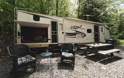 a rv with a picnic table and chairs in front of it at Rv adventure Roscoe Pet friendly in Roscoe
