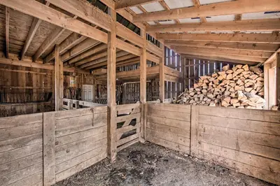 a barn with wooden walls and a pile of logs at Rural Dutch Country Retreat - Private Hot Tub in Dalmatia