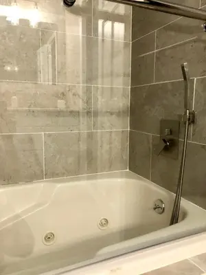 a white bath tub in a bathroom with a shower at Amazing Poconos House . Sauna/Hot Tub/Private Pool in East Stroudsburg