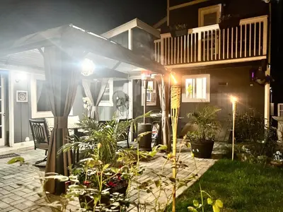 a house with plants in the yard at night at Amazing Poconos House . Sauna/Hot Tub/Private Pool in East Stroudsburg