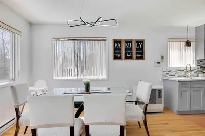 a dining room with a table and white chairs at Cozy Poconos Mountain House with 3 bedrooms in Tobyhanna